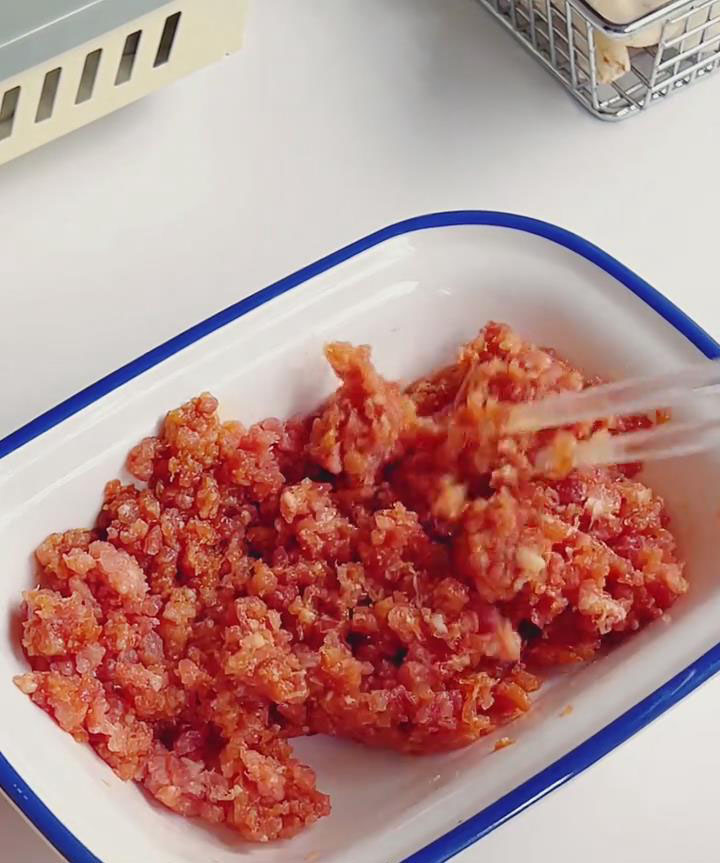 Place ground pork in a bowl with 15ml soy sauce and 15ml cooking wine