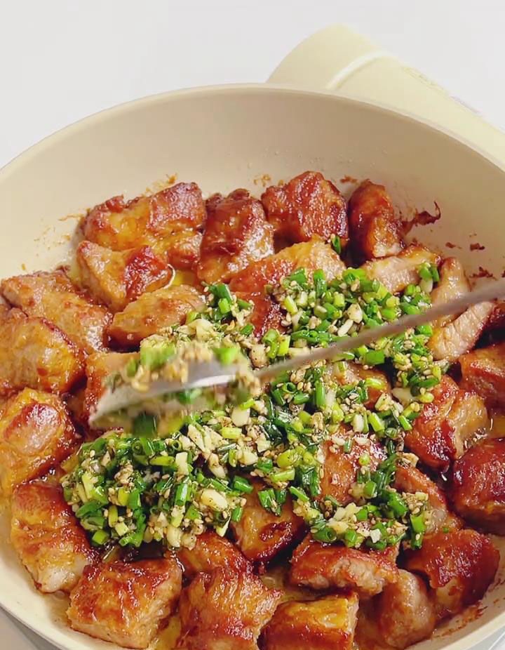 Add the prepared salt scallion sauce to the pan with the pork pieces