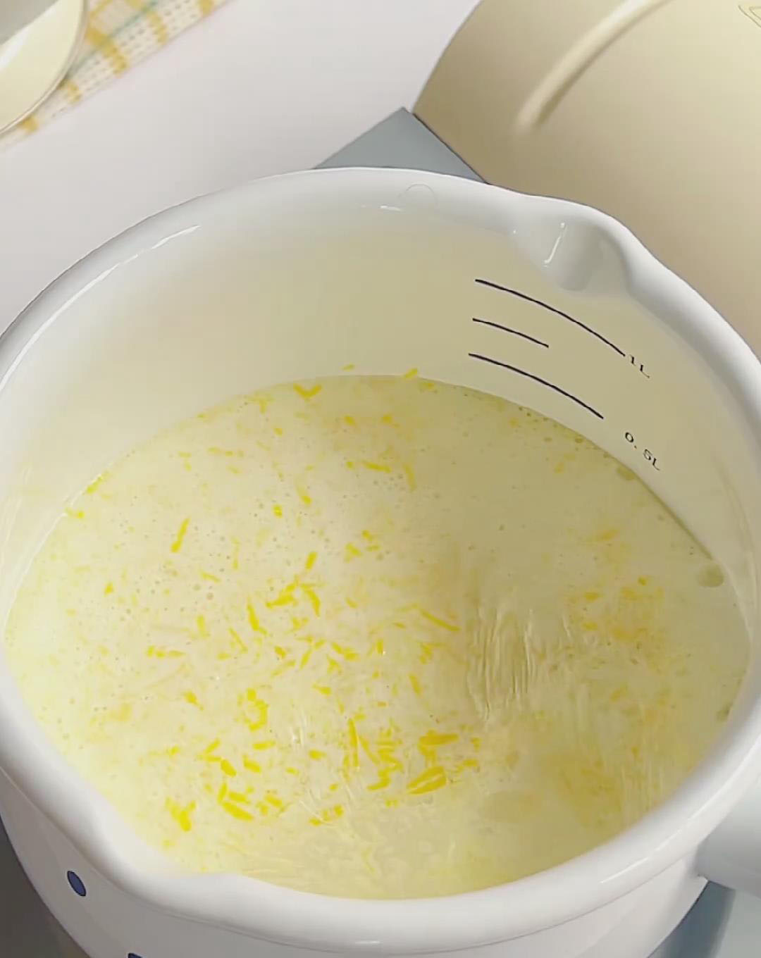 In a small saucepan, add the lemon zest and pour in 250g of milk