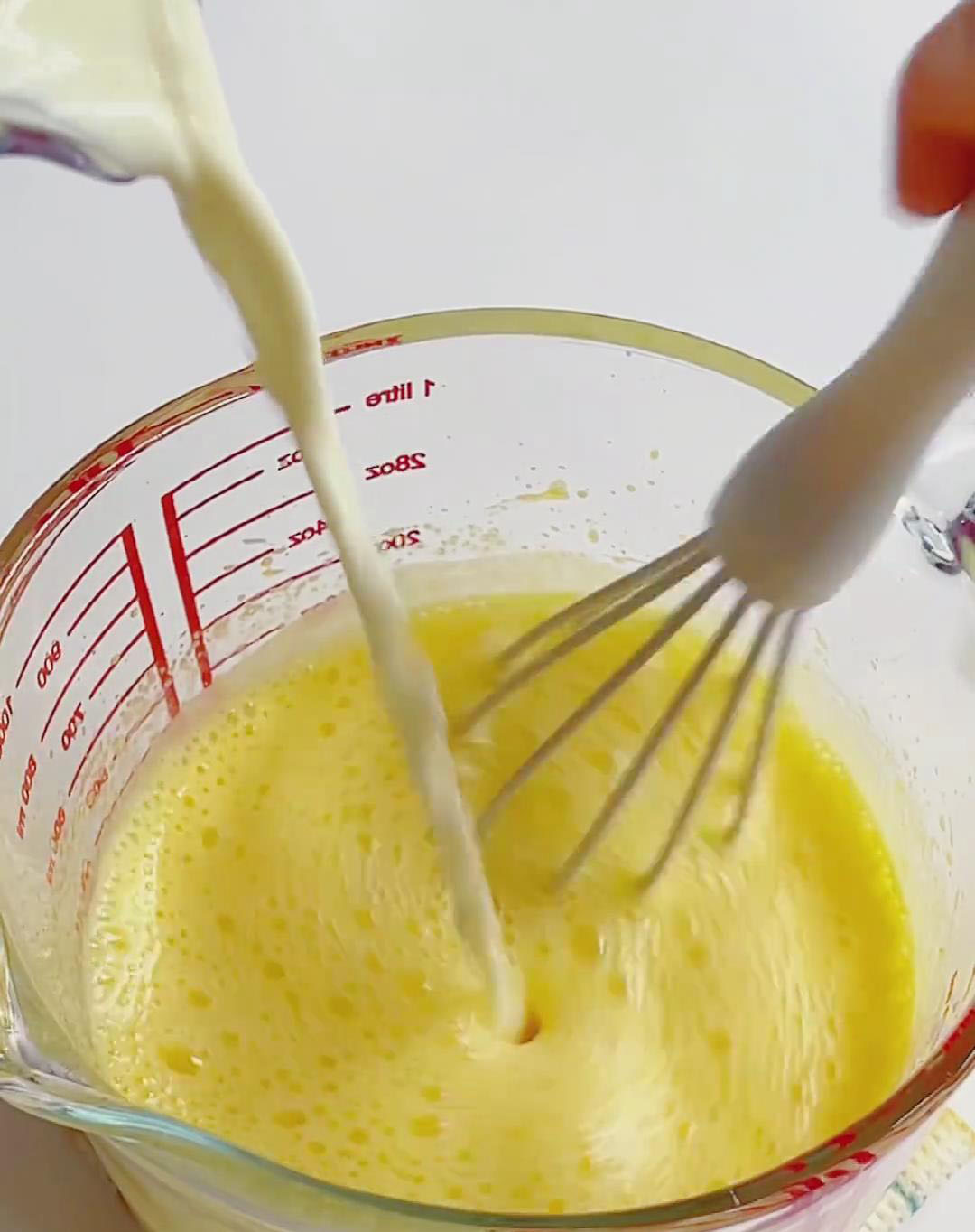Slowly pour the cooled lemon milk into the whipped egg yolks