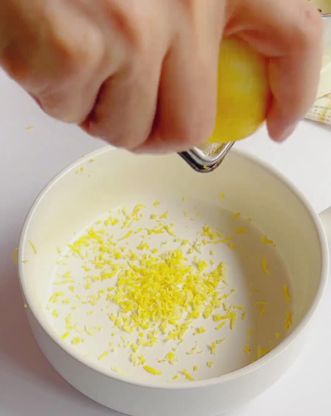 Wash the lemons thoroughly, then zest them using a grater