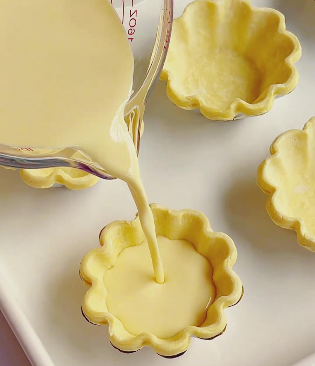 Arrange tart shells on a baking tray and fill each with custard