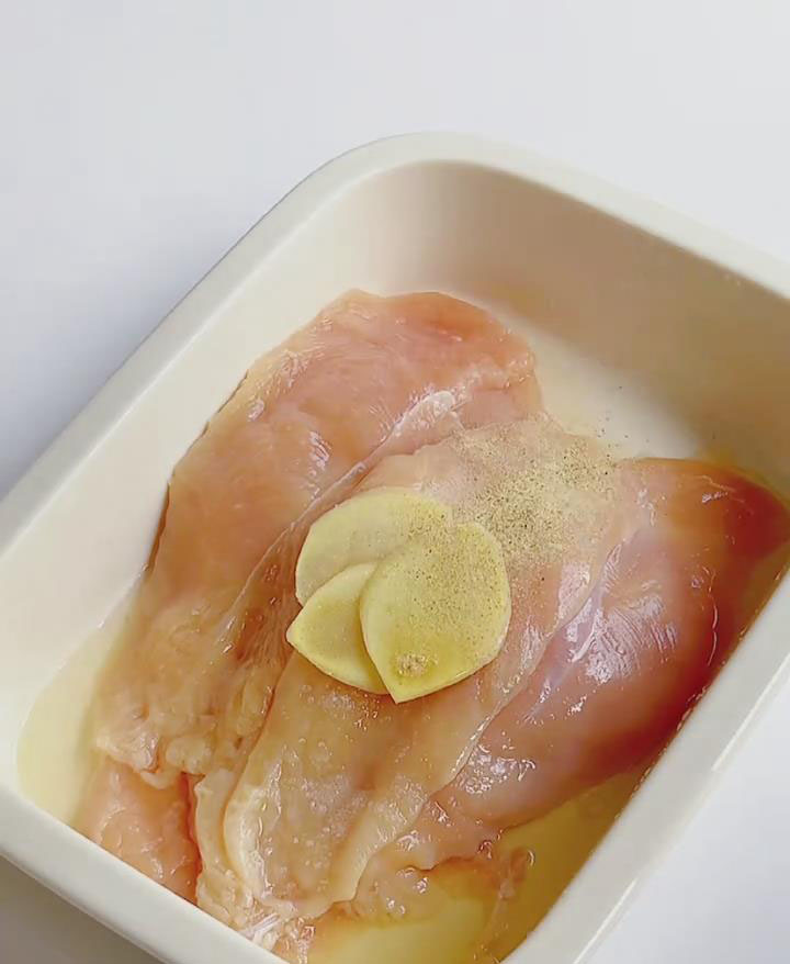 Place the chicken cutlets in a large bowl and add ginger slices, salt, cooking wine, and pepper