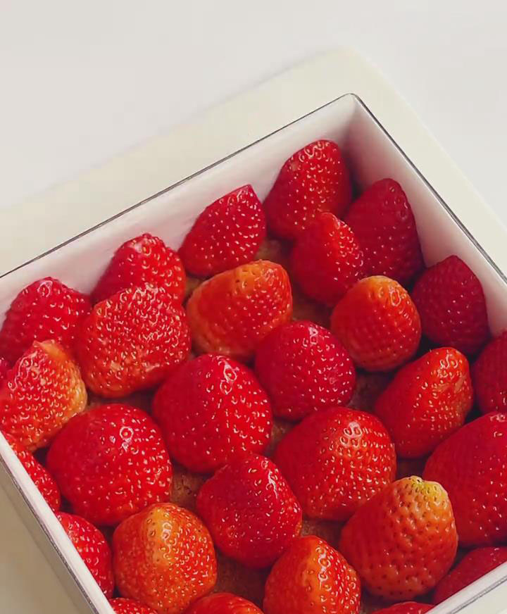 Place the whole strawberries neatly on the base