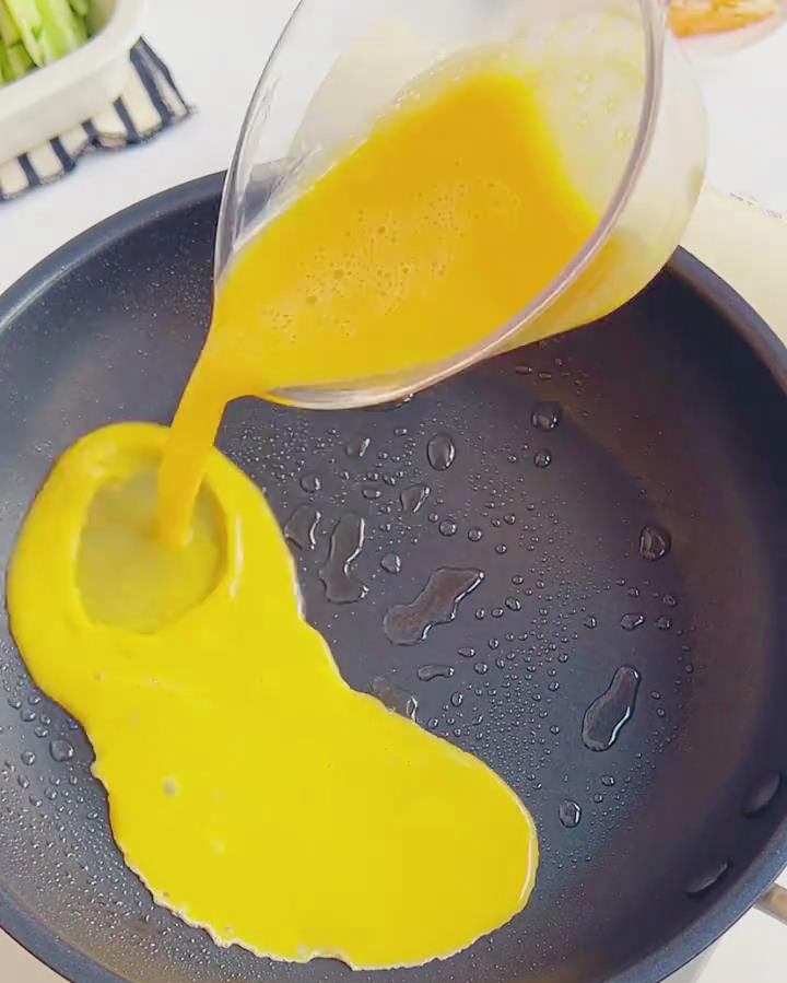 Pour in the beaten eggs and swirl to form a thin layer