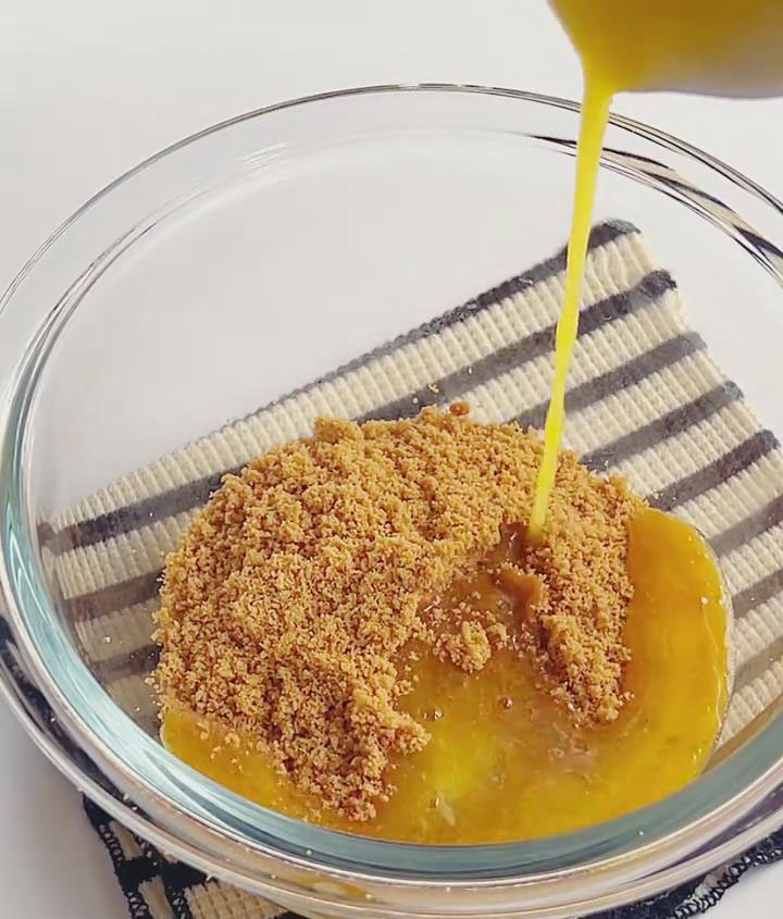 Pour the melted butter over the biscuit crumbs