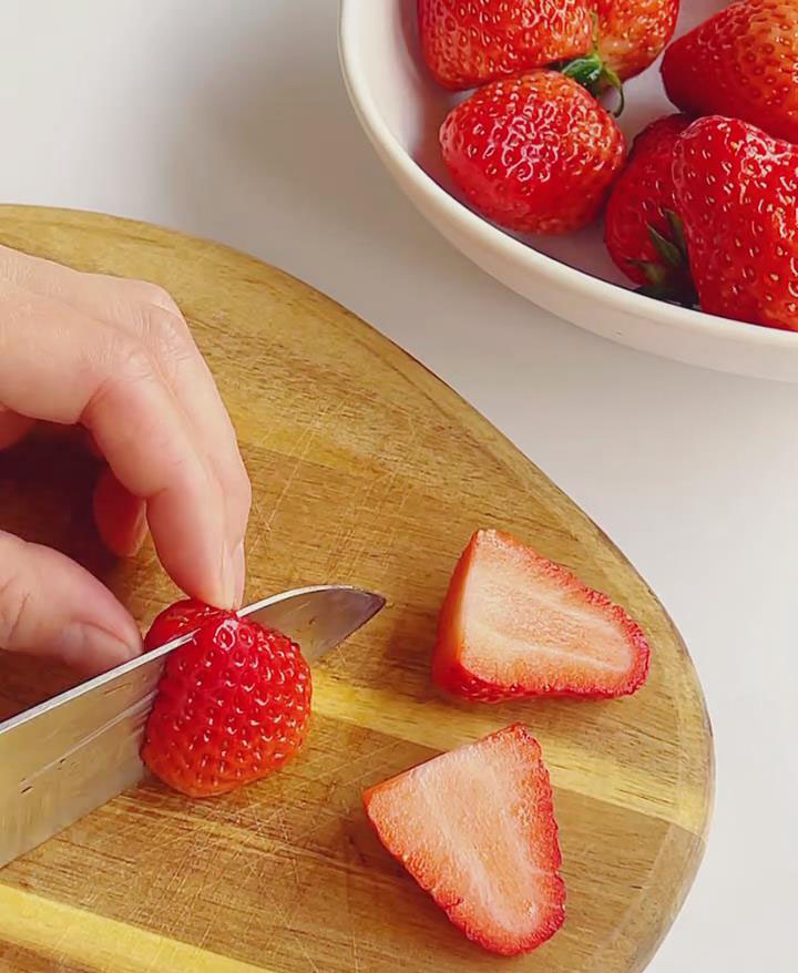 Slice 100g of the strawberries in half
