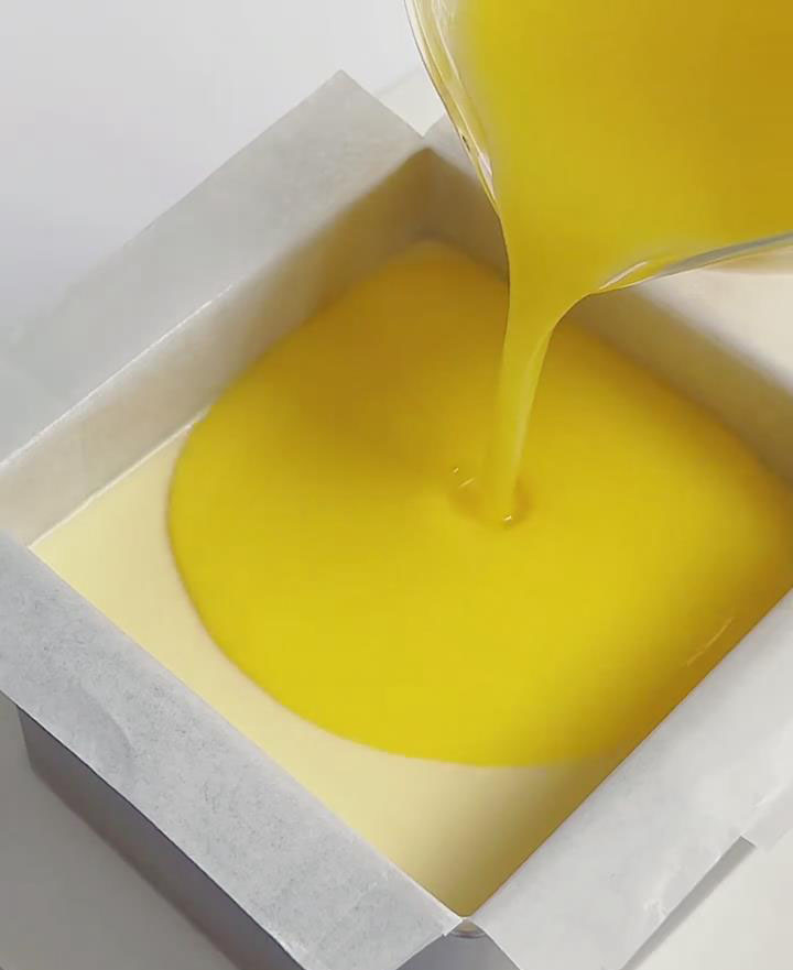 Slowly and evenly pour the cooled lemon topping over the surface of the mousse
