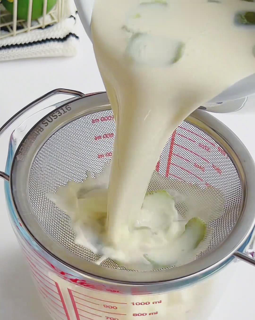 pour the entire panna cotta mixture through a fine mesh sieve into a large jug or bowl