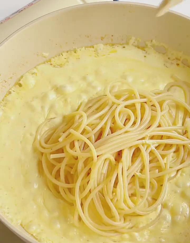 Add the drained pasta and cooked shrimp to the sauce in the skillet