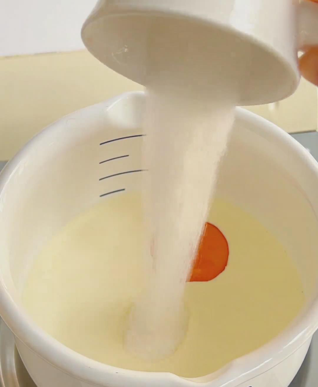 In a small saucepan, pour in 150 g of heavy cream. Add the egg yolk and sugar.