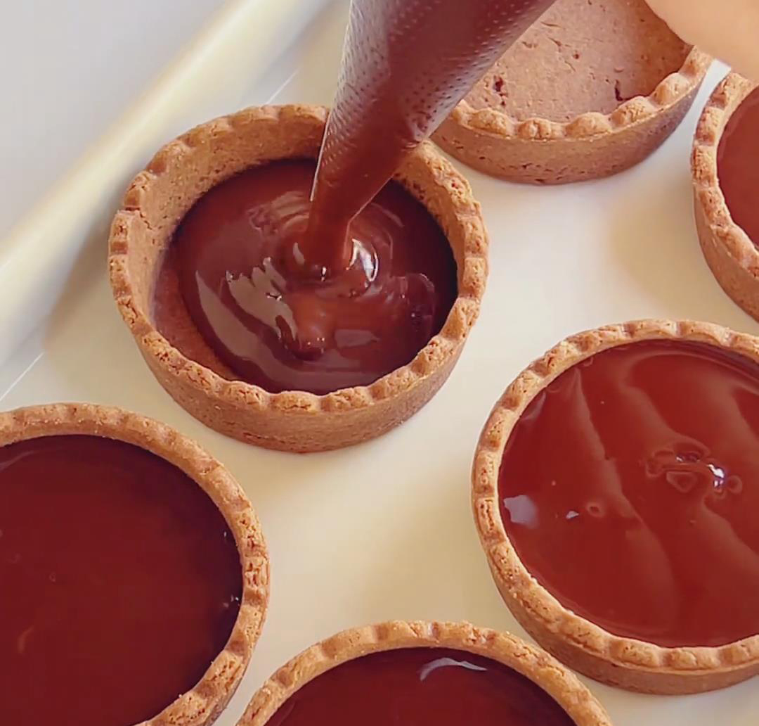 Pipe the chocolate filling into each tart shell