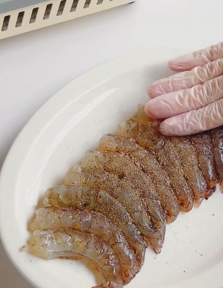 Place the shrimp in a small bowl and season with a little salt and black pepper