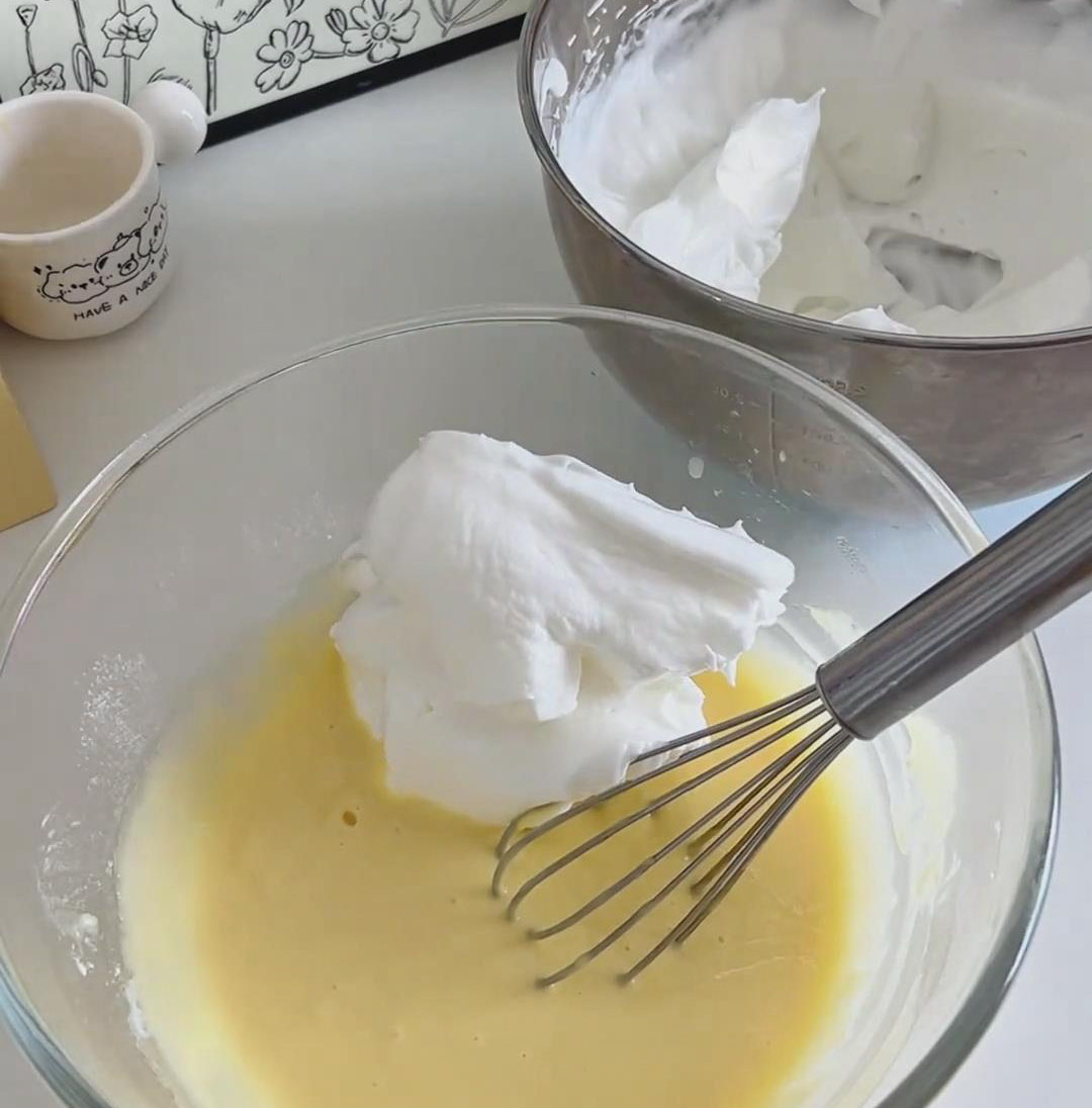 Add about one third of the meringue to the egg yolk batter