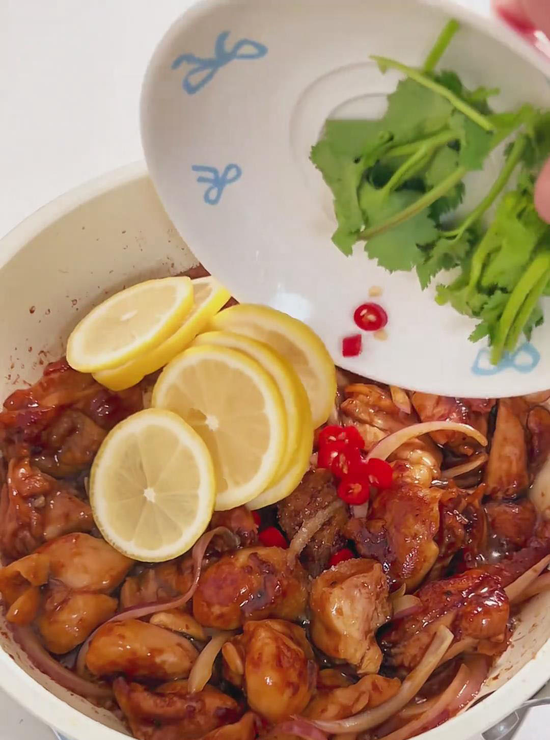 Add the sliced bird's eye chilies, lemon slices, and sugar to the pan