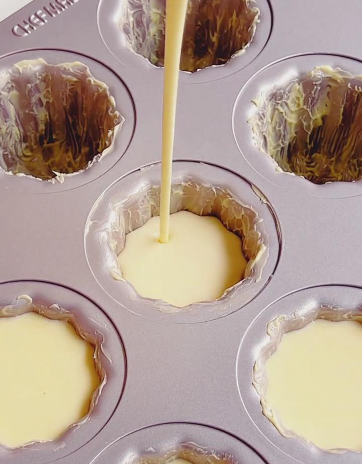 Pour the strained batter slowly into the greased mold