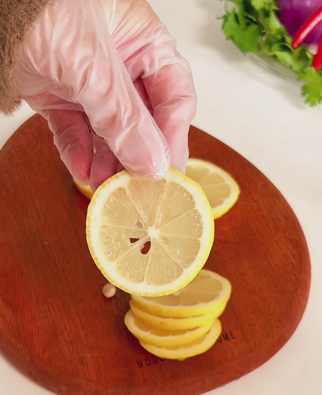 Slice the lemon into thin rounds, and using a toothpick or the tip of a knife, carefully remove all the seeds