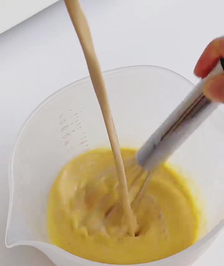 Slowly pour the cooled caramel milk into the eggs