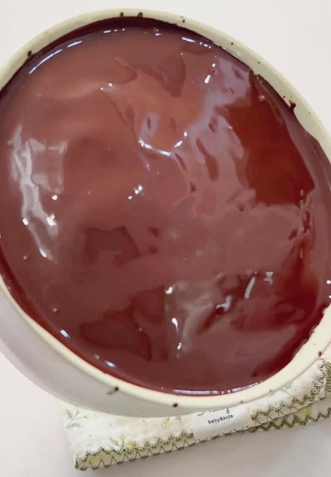 Gently tilt and rotate the mug to encourage the chocolate to flow and cover the entire surface in a thin