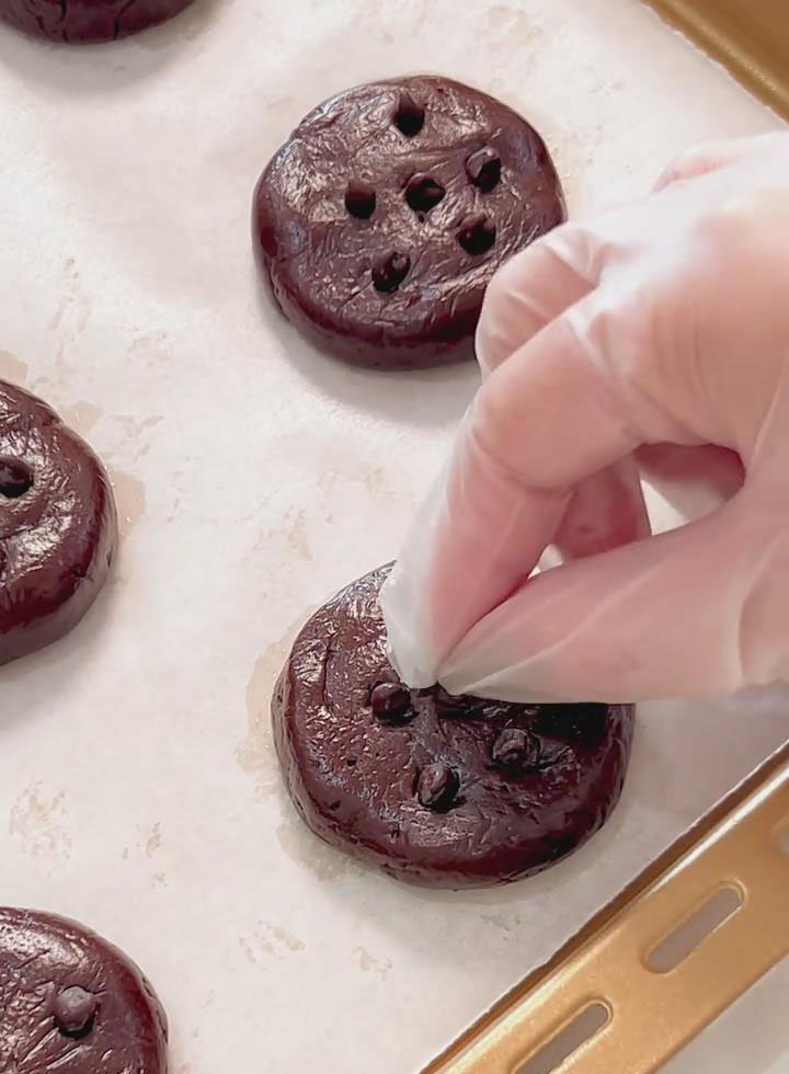 Top each cookie with 5–6 chocolate chips